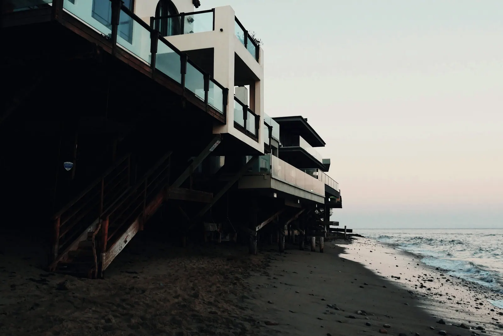 Casa de estrutura leve sobre a areia, ao fim da tarde, com o mar ao lado. Imagem ilustrativa.