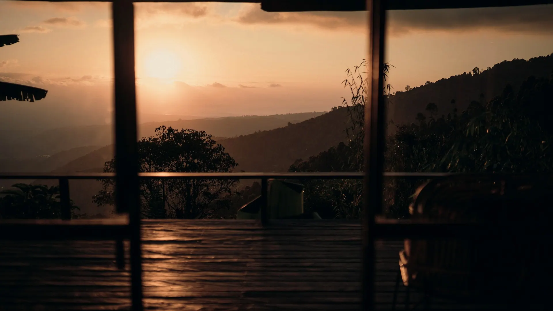 Vista do pôr do sol sobre montanhas a partir de uma varanda. Imagem ilustrativa.