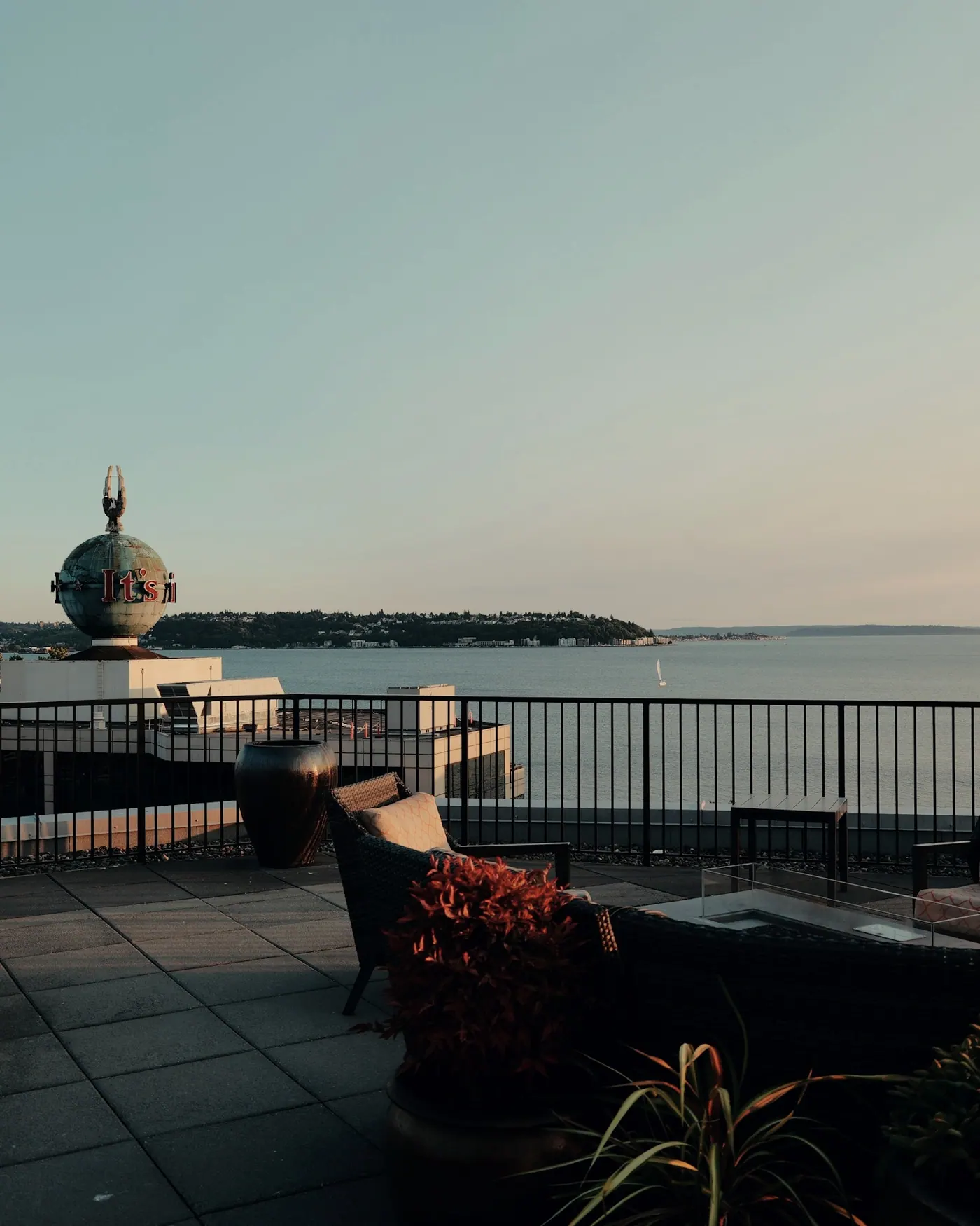Terraço com poltronas e vista aberta para a baía ao entardecer. Imagem ilustrativa.